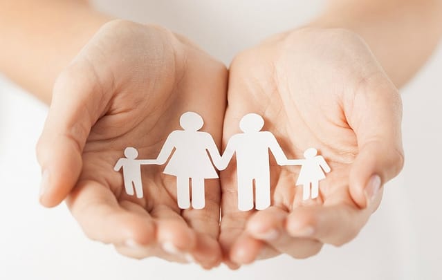 close up of womans cupped hands showing paper man family